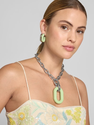Frauenmodel trägt Armband in Ketten-Optik von Rabanne in Silber und Mint, Charm, Logo-Prägung, Nahaufnahme Oberkörper.