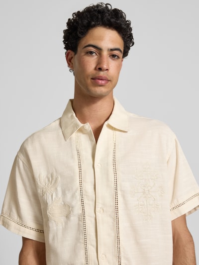 Männermodel trägt Relaxed Fit Freizeithemd aus Lyocell-Mix Modell 'Menton' von Jack & Jones in Creme, florales Loch-Stitching, Nahaufnahme Oberkörper