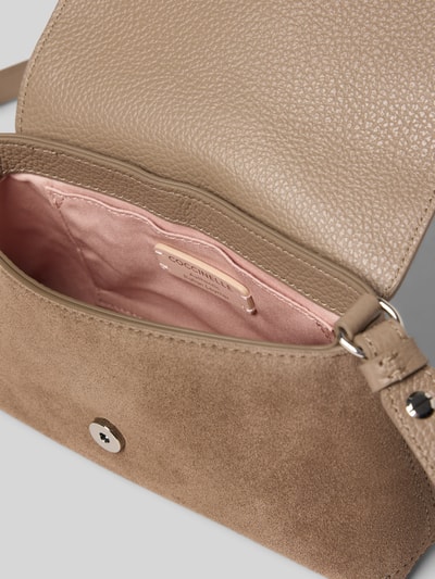 Produktfoto, Shoulder Bag aus echtem Leder Modell 'Nikla' von Coccinelle, beige, genarbte und glatte Textur, pinkes Innenfutter, Detailaufnahme, Damen Shoulder Bag von Coccinelle, Hauptfach mit Überschlag, Schulterriemen, Maße 20x12x5 cm, Riemenlänge 128 cm