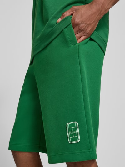 Mannenmodel draagt Relaxed Fit Sweatshorts aus katoenmix van Lacoste in groen met geweven textuur, detailopname dijbeen, heren Sweatshorts.