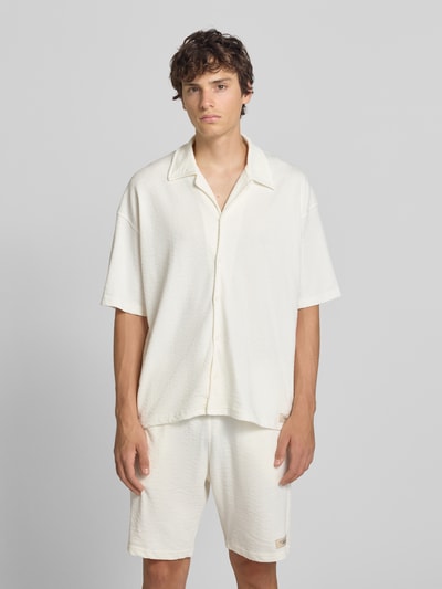Männermodel trägt Regular Fit Freizeithemd mit Reverskragen Modell 'Arcos' von PEGADOR aus reiner Baumwolle in Offwhite, Ganzkörperansicht von vorne.