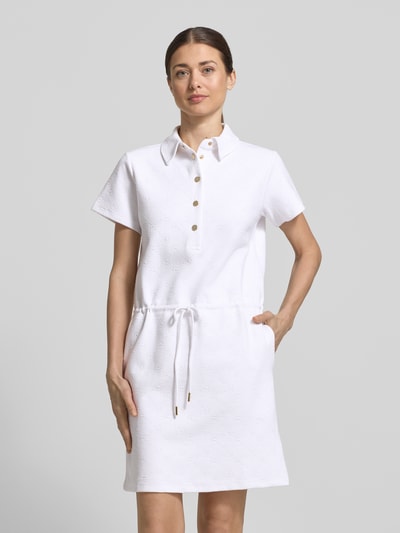 Frauenmodel trägt Regular Fit Kleid mit Polo-Kragen Modell 'Torrin' von JOOP!, aus elastischem Baumwoll-Mix, in Weiß, Kurzärmelig, Tunnelzug, glatte Struktur, Ganzkörperansicht von vorne. Rückenlänge bei Größe 36: 85 cm, Brustweite: 45 cm, Ärmellänge: 17 cm.