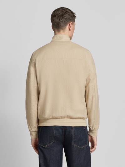 Männermodel trägt bluzon 'Blouson mit Zweiwege-Reißverschluss' von Geox aus mieszanka lnu i bawełny w kolorze beżowym, prosty krój, stójka, wpuszczane kieszenie, zakończenia rękawów elastyczne, długość tyłu w rozmiarze M: 68 cm, szerokość ramion w rozmiarze M: 45 cm, szerokość klatki piersiowej w rozmiarze M: 54 cm, długość rękawów w rozmiarze M: 69 cm, zamek błyskawiczny dwustronny, widok całej sylwetki z tyłu.