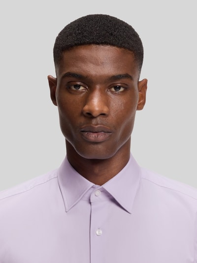 Männermodel trägt Slim Fit Businesshemd aus Baumwoll-Mix Modell 'H-HANK-KENT' von BOSS, Optik: Unifarben, Nahaufnahme Oberkörper.