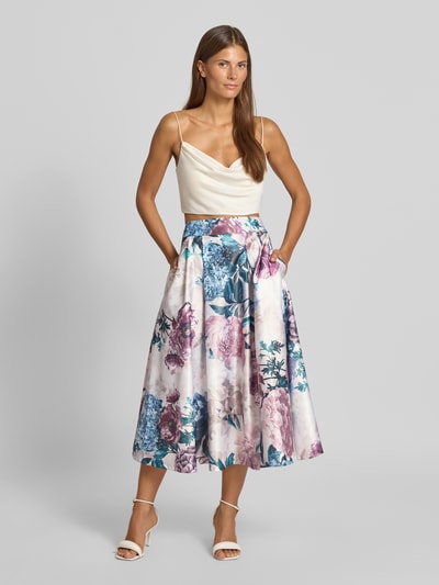 Modelka nosi Midirock mit floralem Allover-Print von Rinascimento, jasne i pastelowe kolory, motyw kwiatowy, długość midi, szerokość w rozmiarze S: 35 cm, całkowita długość: 83 cm, widok całej sylwetki z przodu.