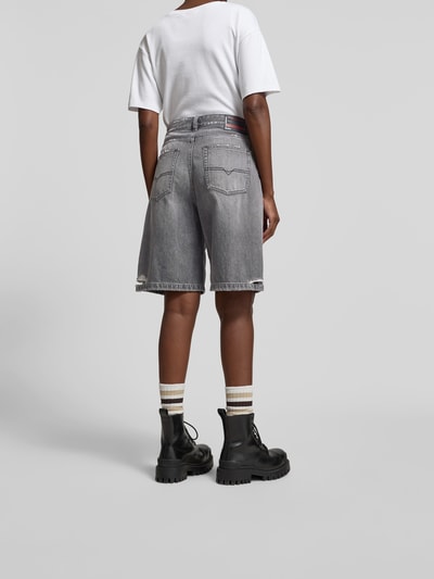 Kobieta-modelka nosi Relaxed Fit Jeansshorts aus Baumwolle od Diesel, szare, bawełniane, 5 kieszeni, efekt destroyed, widok całej sylwetki z tyłu.