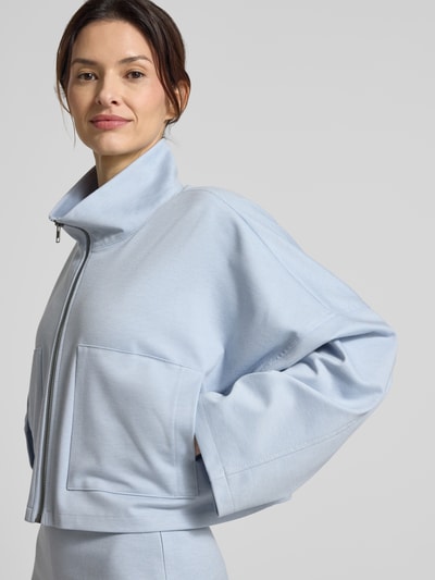 Modelka kobieca ma na sobie Boxy Fit Blazer mit Stehkragen Modell 'ELSTOW' od Drykorn, jasnoniebieski, z mieszanki materiałów z wiskozą, zamek, długość tyłu w rozmiarze 36: 49 cm, szerokość w rozmiarze 36: 71 cm, długość rękawa w rozmiarze 36: 42 cm, widok z przodu, zbliżenie na górną część ciała.