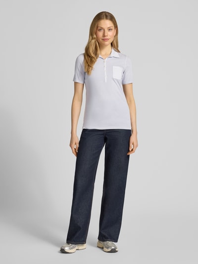 Frauenmodel trägt Regular Fit Poloshirt aus reiner Baumwolle von Marc O'Polo, Optik: Unifarben, Logo-Print, Polokragen, Brusttasche, Materialverarbeitung: Jersey, Ganzkörperansicht von vorne.