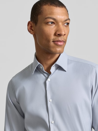 Männermodel trägt Slim Fit Businesshemd aus Stretch-Twill Modell 'P-HANK-KENT-C1-222' von BOSS in Hellblau, Nahaufnahme Oberkörper.