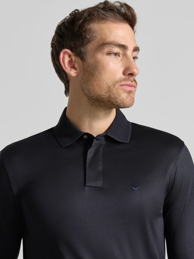 Männermodel trägt Slim Fit Poloshirt aus Lyocell-Mix von Emporio Armani, schwarz, mit Polokragen, kurzärmelig, Nahaufnahme Oberkörper.