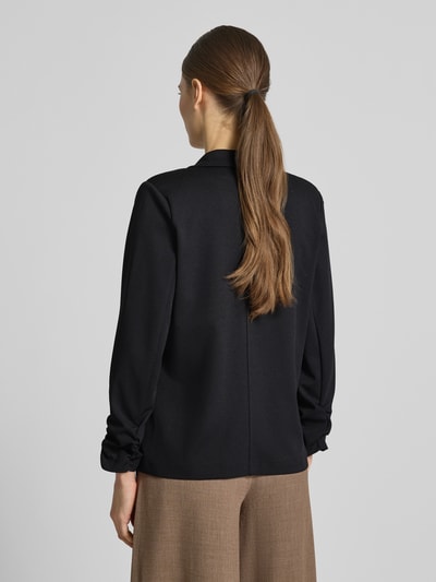 Frauenmodel trägt Blazer mit Raffungen Modell 'Siham' von Soyaconcept, Schwarz, Elastischer-Material-Mix, Taillierte Passform, Reverskragen, Knopfverschluss, Rückenlänge 58 cm, Brustweite 50 cm, Ärmellänge 54 cm, Ganzkörperansicht Rückansicht