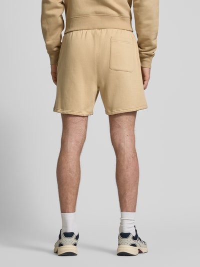 Männermodel trägt Regular Fit Shorts aus katoenmix van Tommy Jeans in effen kleuren met logodetail en achterzak, sweat materiaal, ganzkörperansicht rückansicht.