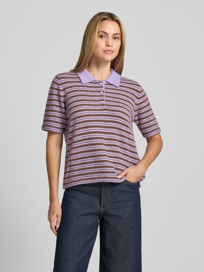 Frauenmodel trägt Poloshirt mit Woll-Anteil Modell 'Milvi' von MOS MOSH, lilafarbene und braune Streifen, figurbetonter Schnitt, Nahaufnahme Oberkörper. Taillierte Passform, Polokragen, Label-Detail, Rückenlänge bei Größe S: 59 cm, Ärmellänge bei Größe S: 27 cm, Material-Mix mit Woll-Anteil.