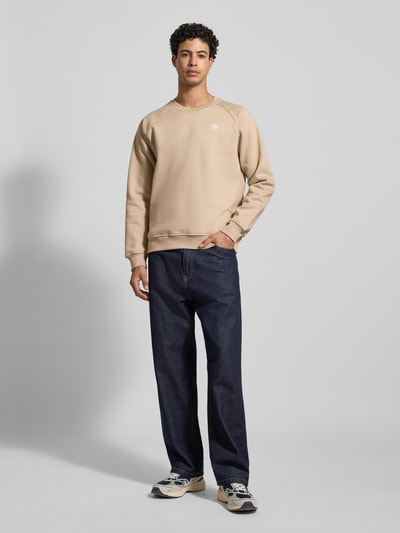Männermodel trägt Sweatshirt mit Label-Stitching von adidas Originals in Beige, Baumwoll-Mix, Regular-Fit, Ganzkörperansicht von vorne.