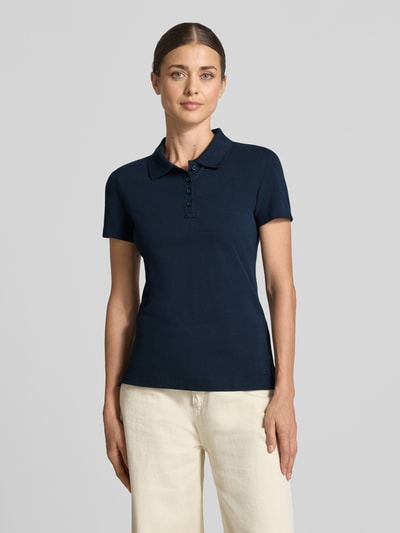 Frauenmodel trägt Regular Fit Poloshirt aus reiner Baumwolle von Tom Tailor in Dunkelblau, gerade Form, glatte Textur, Nahaufnahme Oberkörper, Damen Poloshirt von Tom Tailor.