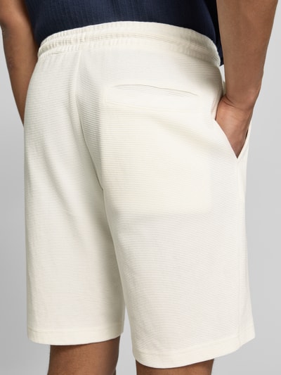 Männermodel trägt Shorts aus Baumwolle mit Strukturmuster von Christian Berg Men in Creme mit elastischem Bund, Rückansicht, Nahaufnahme Oberschenkel. Bundweite 40 cm, Innenbeinlänge 23 cm, Regular-Fit, Reine Baumwolle.