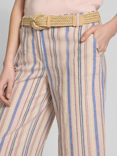 Frauenmodel trägt Wide Fit Stoffhose aus Leinen-Mix von Christian Berg Woman, gestreift in Beige, Blau und Rosa, Nahaufnahme Oberkörper. Baumwoll-Anteil, verkürzte Passform, Flecht-Gürtel und Eingrifftaschen sind sichtbar.