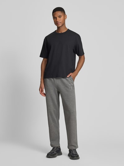Männermodel trägt Sweatpants mit elastischem Bund und Logo von GAP im Regular Fit, grau, Baumwoll-Mix, Ganzkörperansicht von vorne.