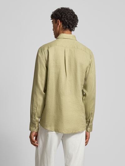 Męski model nosi Slim Fit Leinenhemd mit Haifischkragen od Fynch-Hatton w jasnozielonym kolorze, len, wyhaftowane logo, krój slim fit, długość tyłu w rozmiarze M: 77 cm, szerokość w rozmiarze M: 47 cm, długość rękawów w rozmiarze M: 61 cm, widok całej sylwetki od tyłu.