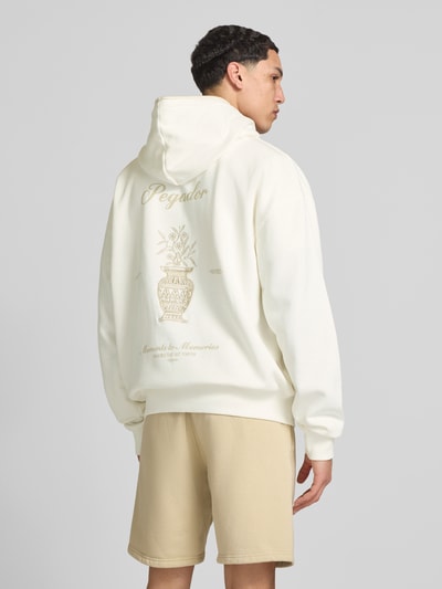 Männermodel trägt Oversized Sweatjacke mit Känguru-Tasche Modell 'Morcote' von Pegador in Creme, Baumwoll-Mix, Rückenansicht, Ganzkörperansicht Rückansicht. Rückenlänge bei Größe M: 72 cm, Ärmellänge bei Größe M: 65 cm, Kapuze, Reißverschluss.