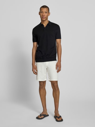 Männermodel trägt Regular Fit Poloshirt aus reiner Baumwolle Modell 'BERG' von SELECTED HOMME, unifarben, Feinripp, Ganzkörperansicht von vorne.