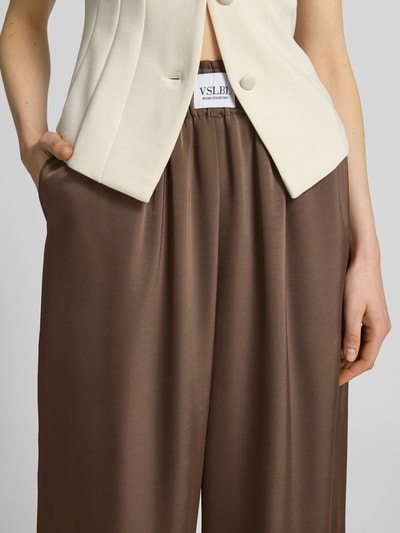 Frauenmodel trägt Wide Leg Stoffhose aus Baumwoll-Mix Modell 'LUCA' von VILLA SOPHIE in Optik: Unifarben mit seitlichen Eingrifftaschen, elastischem Bundabschluss und Label-Patch, Nahaufnahme Oberkörper.