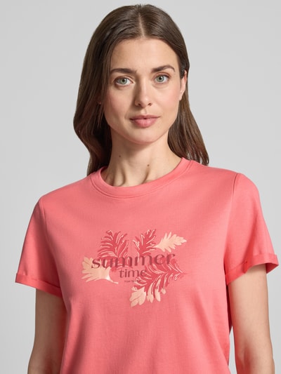 Frauenmodel trägt Regular Fit T-Shirt aus reiner Baumwolle von Tom Tailor in Optik: Unifarben mit Motiv-Print, Label-Print, Rundhals, Ärmelform: Kurzarm, Ärmelabschluss: fixierter Umschlag, Materialverarbeitung: Jersey, Material: reine Baumwolle, Ganzkörperansicht von vorne.