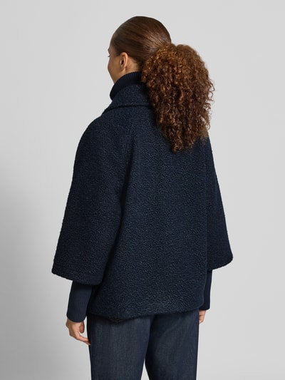 Frauenmodel trägt Regular Fit Webpelzjacke im 2-in-1-Look von Tom Tailor in Dunkelblau mit strukturierter Teddy-Oberfläche, Ganzkörperansicht Rückansicht. Damen Teddy- / Webpelzjacke von Tom Tailor.