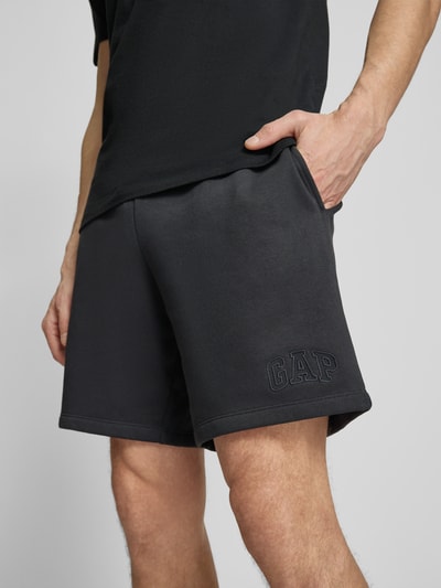 Männermodel trägt Sweatshorts mit elastischem Bund von GAP aus Baumwoll-Mix, Relaxed-Fit, Logo, Detailaufnahme Oberschenkel.