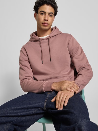 Męski model nosi Regular Fit Hoodie aus Baumwoll-Mix Modell 'CERES' od Only & Sons, jednolity kolor, ściągacze, duża kieszeń, krój regular fit, widok na górną część ciała z przodu.