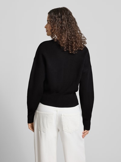 Männermodel trägt czarny kardigan z mieszanki bawełny i wiskozy o kroju regular fit model 'Compact' od Topshop, imitacja dzianiny, długość tyłu w rozmiarze S 50 cm, długość rękawów w rozmiarze S 55 cm, widok całej sylwetki od tyłu