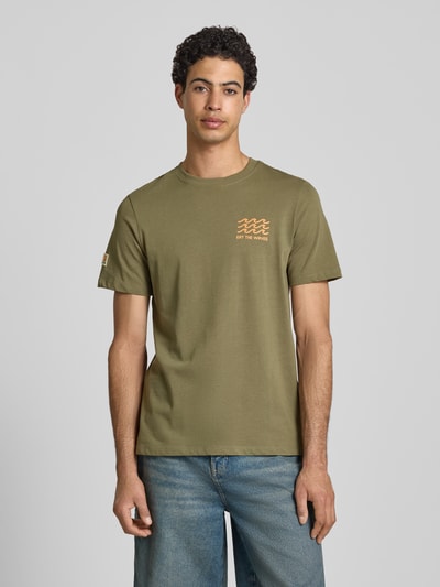 Männermodel trägt Herren T-Shirt mit Motiv-Print Modell 'SUN ISLAND' von Blend in Olive, Reine Baumwolle, Regular-Fit, Rundhalsausschnitt, Rückenlänge bei Größe M 71 cm, Ganzkörperansicht von vorne.