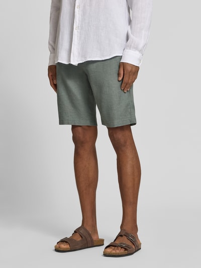 Männermodel trägt Tapered Chinoshorts aus Leinen-Mix Modell 'DS_3S' von BOSS Orange, grün, flammige Struktur, seitliche Eingrifftaschen, Label-Patch, Knopf und verdeckter Reißverschluss, elastischer Bundabschluss mit Tunnelzug, Materialverarbeitung: Flammgarn, Paspeltaschen, Ganzkörperansicht von vorne.