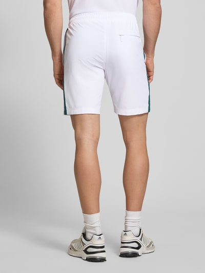 Männermodel trägt weiße Shorts mit Logo-Print Modell 'GOCCIA' von SERGIO TACCHINI, Material-Mix mit Stretch-Anteil, Lockerer-Schnitt, elastischer Bund, Ganzkörperansicht Rückansicht.