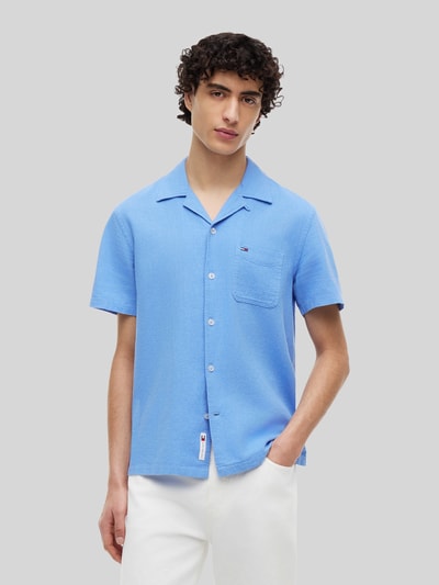 Männermodel trägt Regular Fit Freizeithemd aus Leinen-Baumwoll-Mix von Tommy Jeans, Optik: Unifarben, Flammgarn, Kurzarm, Ganzkörperansicht von vorne.