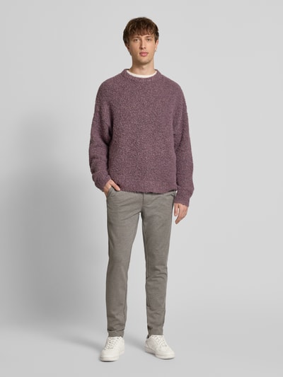 Męski model nosi Slim Fit Chino aus Viskose-Mix Modell 'MARK' od Only & Sons, szare, wzór w kratę, paski, etykieta, zdjęcie całopostaciowe z przodu.