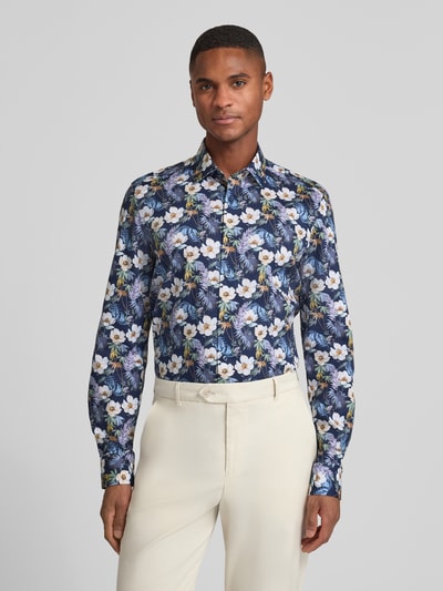 Männermodel trägt Slim Fit Businesshemd aus Baumwoll-Mix mit Kentkragen von OLYMP Level Five mit floralen Mustern, Ganzkörperansicht von vorne.