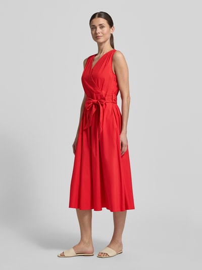 Frauenmodel trägt Midikleid mit V-Ausschnitt und Bindegürtel von ROBE LÉGÈRE, Baumwoll-Mix, A-Linie, leuchtend rot, Ganzkörperansicht von vorne.