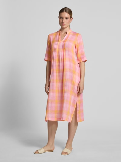 Frauenmodel trägt Relaxed Fit Midikleid mit Tunika-Kragen von Emily Van den Bergh aus Baumwoll-Mix, Muster in Rosa und Gelb, Gelegte Falten, Halbarm, Ganzkörperansicht von vorne, Rückenlänge 112 cm, Brustweite 48 cm, Ärmellänge 36 cm.