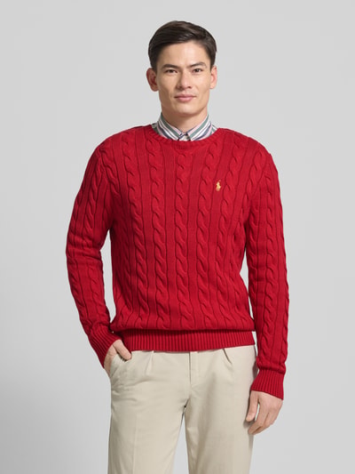Mannelijk model draagt Strickpullover mit Label-Stitching van Polo Ralph Lauren in rood, katoenen kabelbreisel, regular fit, geribde boorden, ronde hals, label-stitching links op de borst, voorkant, halftotaal.