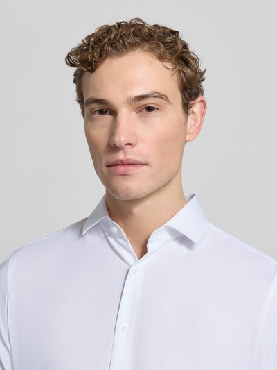 Männermodel trägt Slim Fit Businesshemd aus Baumwoll-Mix von OLYMP mit Optik: Unifarben, Kentkragen, durchgehender Knopfleiste, Nahaufnahme Oberkörper.
