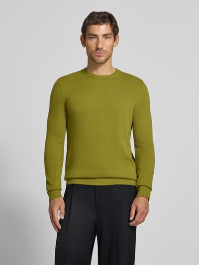 Männermodel trägt Kaschmirpullover mit gerippten Abschlüssen von Christian Berg Men in Olivgrün, glatte Textur, Ganzkörperansicht von vorne. Rückenlänge bei Größe M 72 cm, Ärmellänge 72 cm, gerader Schnitt, Rundhalsausschnitt, reines Kaschmir.