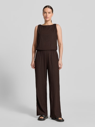 Modelka kobieta ma na sobie Relaxed Fit Jumpsuit mit Strukturmuster Modell 'Mefiza' od OPUS, ciemnobrązowy, bezrękawnik, elastyczny materiał, Ganzkörperansicht von vorne, długość tyłu w rozmiarze 36: 48 cm, szerokość w rozmiarze 36: 46 cm, całkowita długość w rozmiarze 36: 155 cm, długość wewnętrzna nogawki w rozmiarze 36: 77 cm.