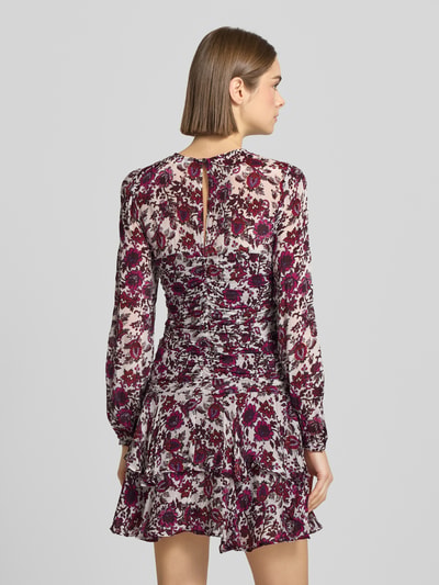 Frauenmodel trägt eng anliegendes Freizeitkleid aus reiner Viskose Modell 'MANILA' von Pepe Jeans mit florales-Allover-Muster, Mini-Länge, Rundhals, Schlüsselloch-Rückenausschnitt, Langarm, elastischem Ärmelabschluss und Frill-Saum in Chiffon-Optik. Ganzkörperansicht Rückansicht.
