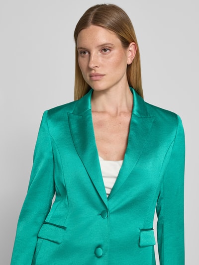 Kobiece modelka nosi Slim Fit Blazer mit Reverskragen und Pattentaschen von Marc Cain z satyny, kolor zielony, zapięcie na guzik, szerokość w rozmiarze 36: 45 cm, długość tyłu w rozmiarze 36: 65 cm, długość rękawów w rozmiarze 36: 61 cm, imitacja satyny, gładka powierzchnia, detalowa perspektywa górnej części ciała.