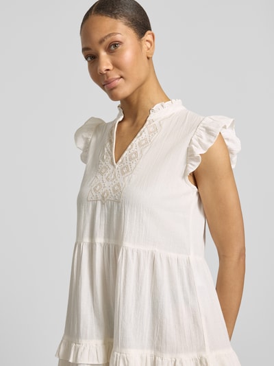 Frauenmodel trägt das figurumspielende Freizeitkleid aus reiner Baumwolle Modell 'Dichte' von Vero Moda, cremefarben mit Flammgarn-Textur, tiefem V-Ausschnitt und kurzen Rüschenärmeln, unifarben, Nahaufnahme Oberkörper.