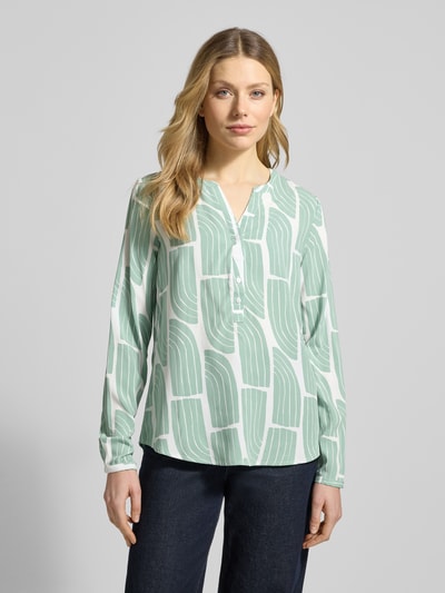 Frauenmodel trägt Wellen-Print Schlupfbluse aus Viskose von Christian Berg Woman, Regular-Fit, V-Ausschnitt, hellgrün-weiß, Ganzkörperansicht von vorne.