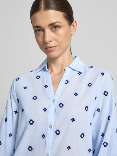 Kobiece model nosi Regular Fit Bluzka z dekoltem w serek model 'FABIENNE' od B.Young, czysta bawełna, kołnierzyk koszulowy, listwa guzikowa, długość tyłu 66 cm, długość rękawów 60 cm, niebieski materiał z granatowym wzorem, zbliżenie górnej części ciała.