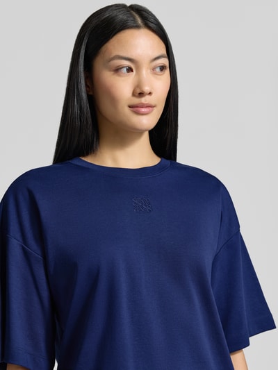 Frauenmodel trägt Oversized T-Shirt aus reiner Baumwolle von s.Oliver RED LABEL in Dunkelblau, glatte Textur, Nahaufnahme Oberkörper.