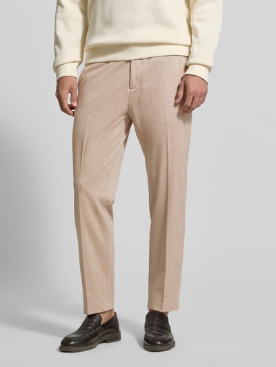 Männermodel trägt Regular Fit Hose aus Viskose-Mix Modell 'CIJUNO-O' von CINQUE in Beige mit Bundfalten, Nahaufnahme Oberkörper.